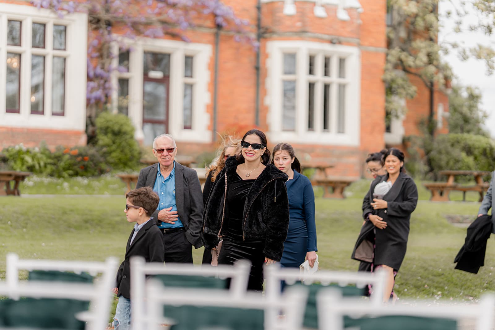 Guests arriving past the wisteria-covered facade of Highley Manor