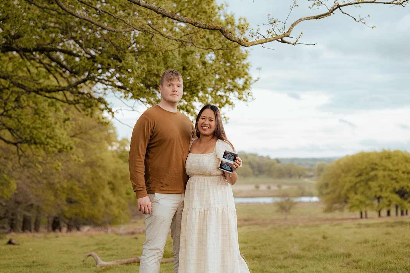 Family portrait with baby reveal announcement in a park, London