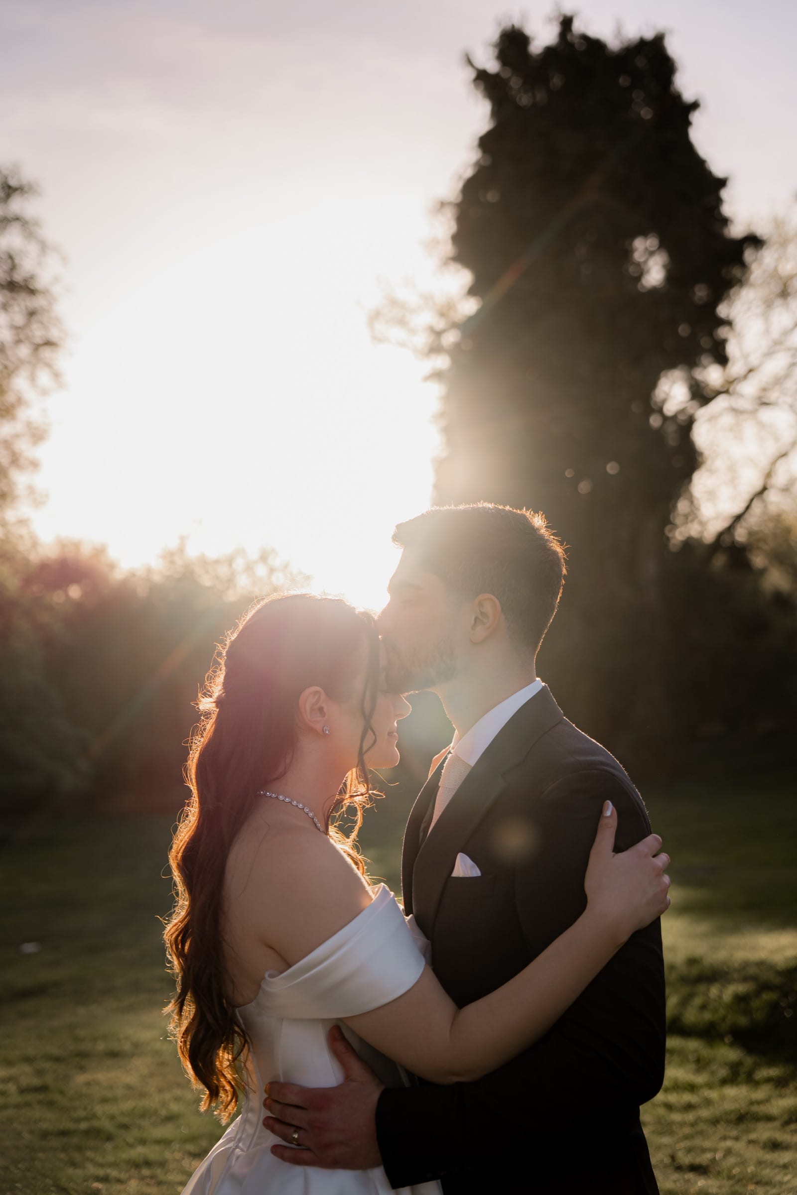 A couple holding each other in golden evening light after their wedding
