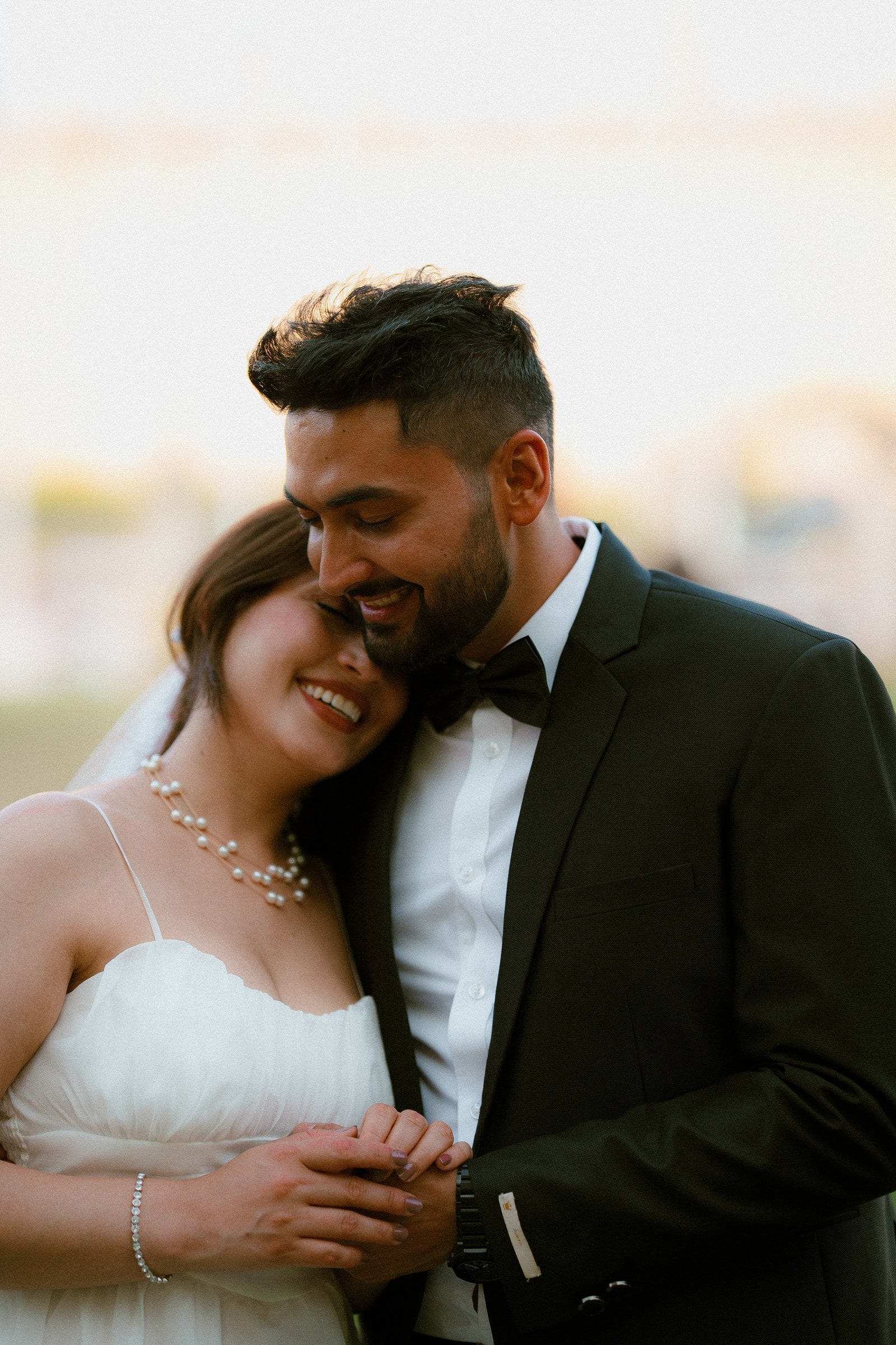 A close, warm embrace during a London pre-wedding shoot, her head resting against his chest