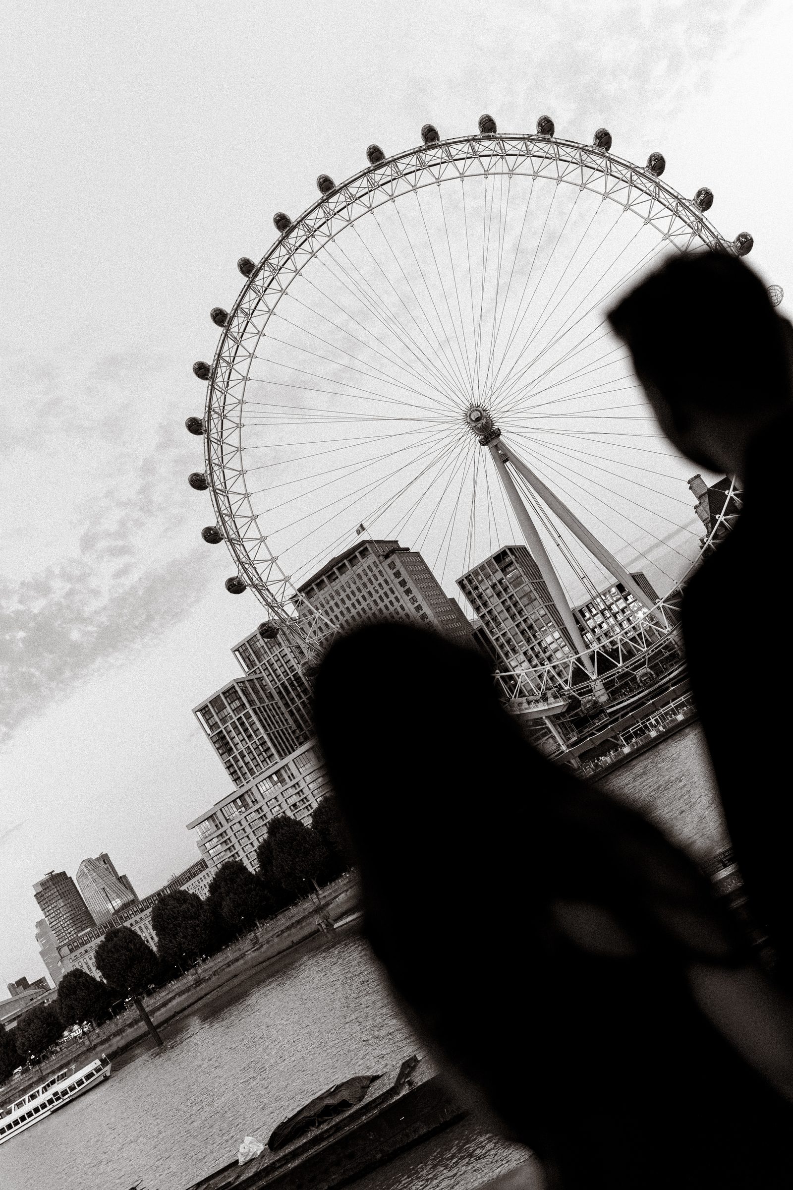 A black and white silhouette of the couple in front of the London Eye and the Thames skyline