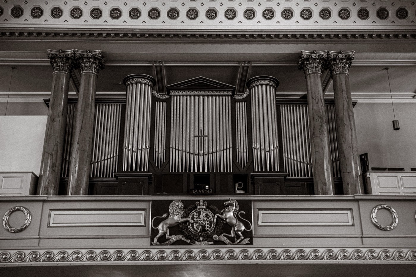 The organ gallery and royal coat of arms inside All Souls, Langham Place, in black and white