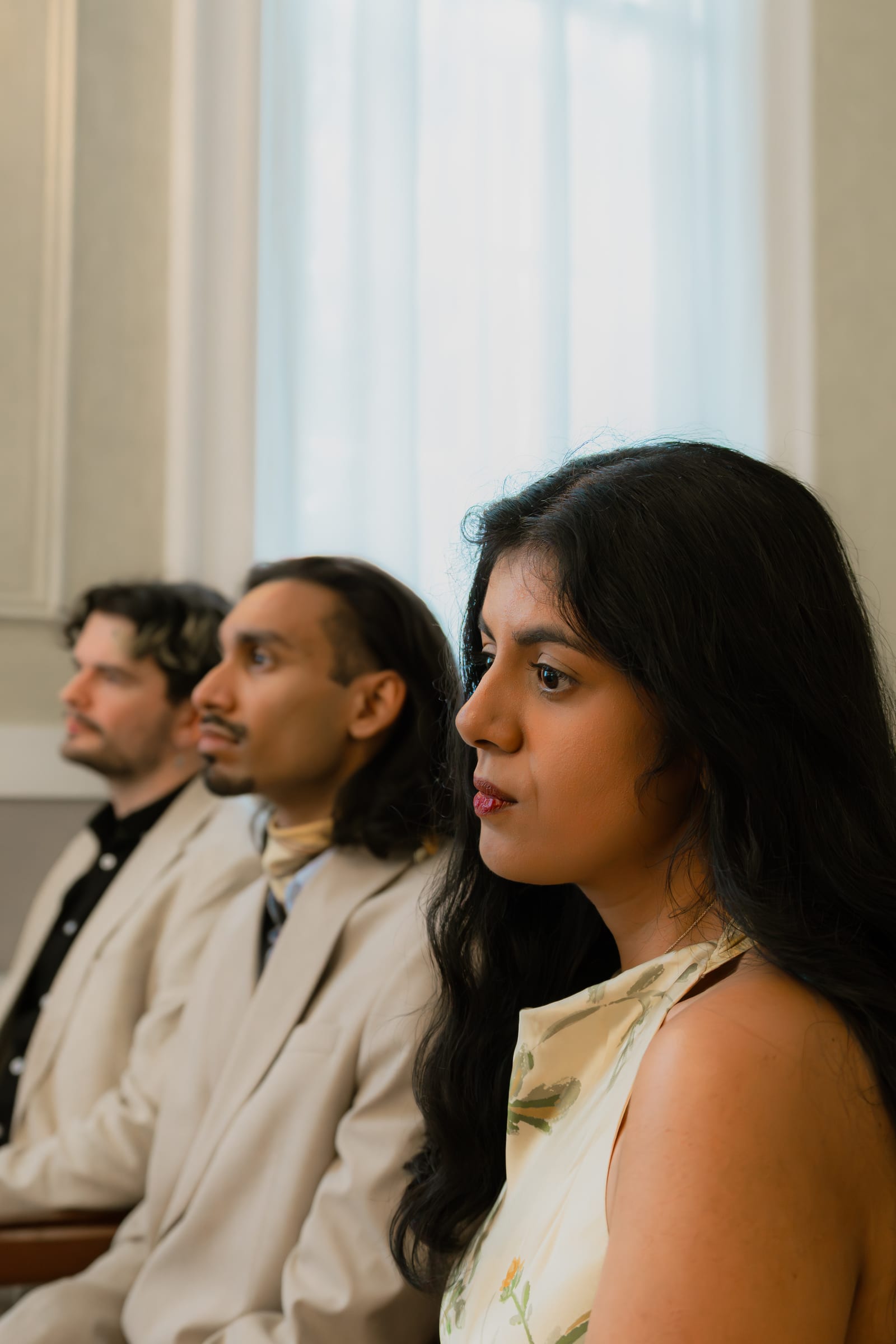 Guests watching a wedding ceremony in a daylit panelled room at Chelsea Old Town Hall