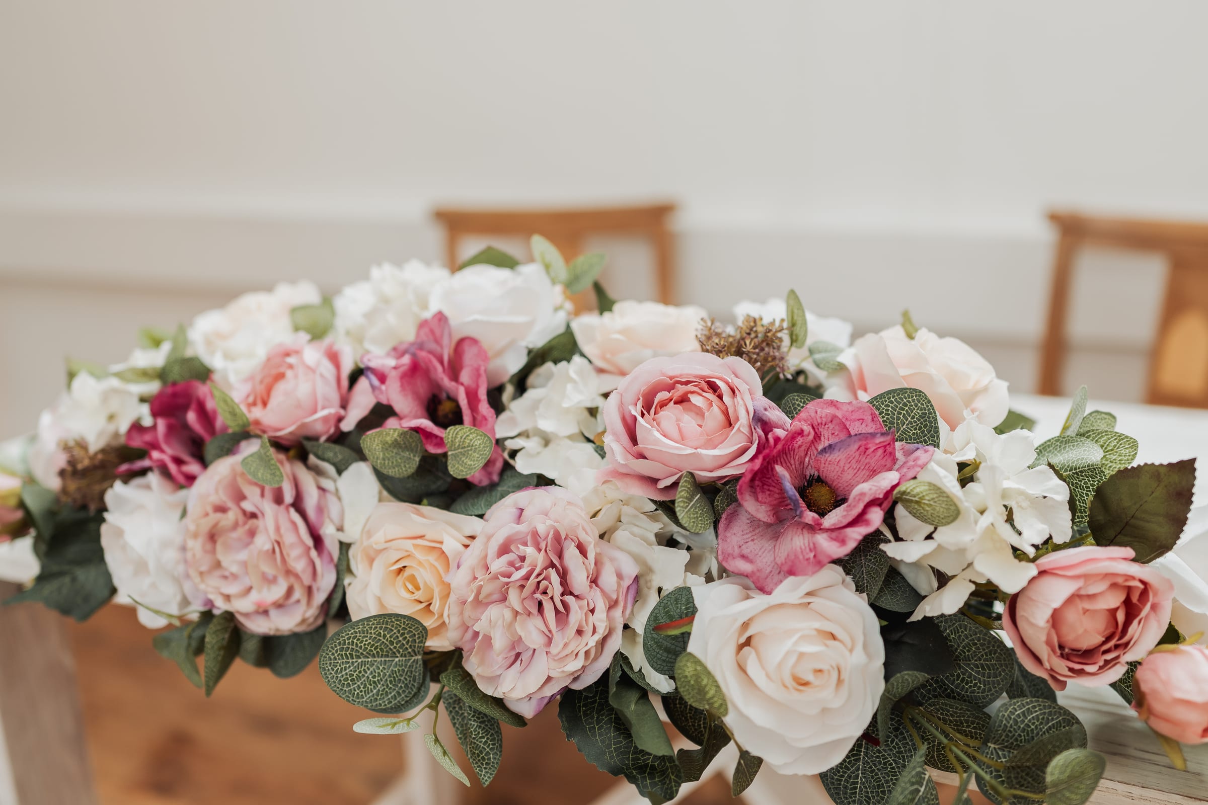 Soft florals on the registrar’s table in a bright civil ceremony room