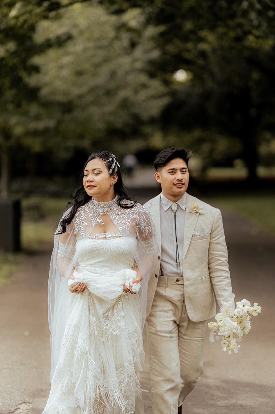 A couple walking through a leafy South London park after their intimate wedding, photographed by Evocation Photography