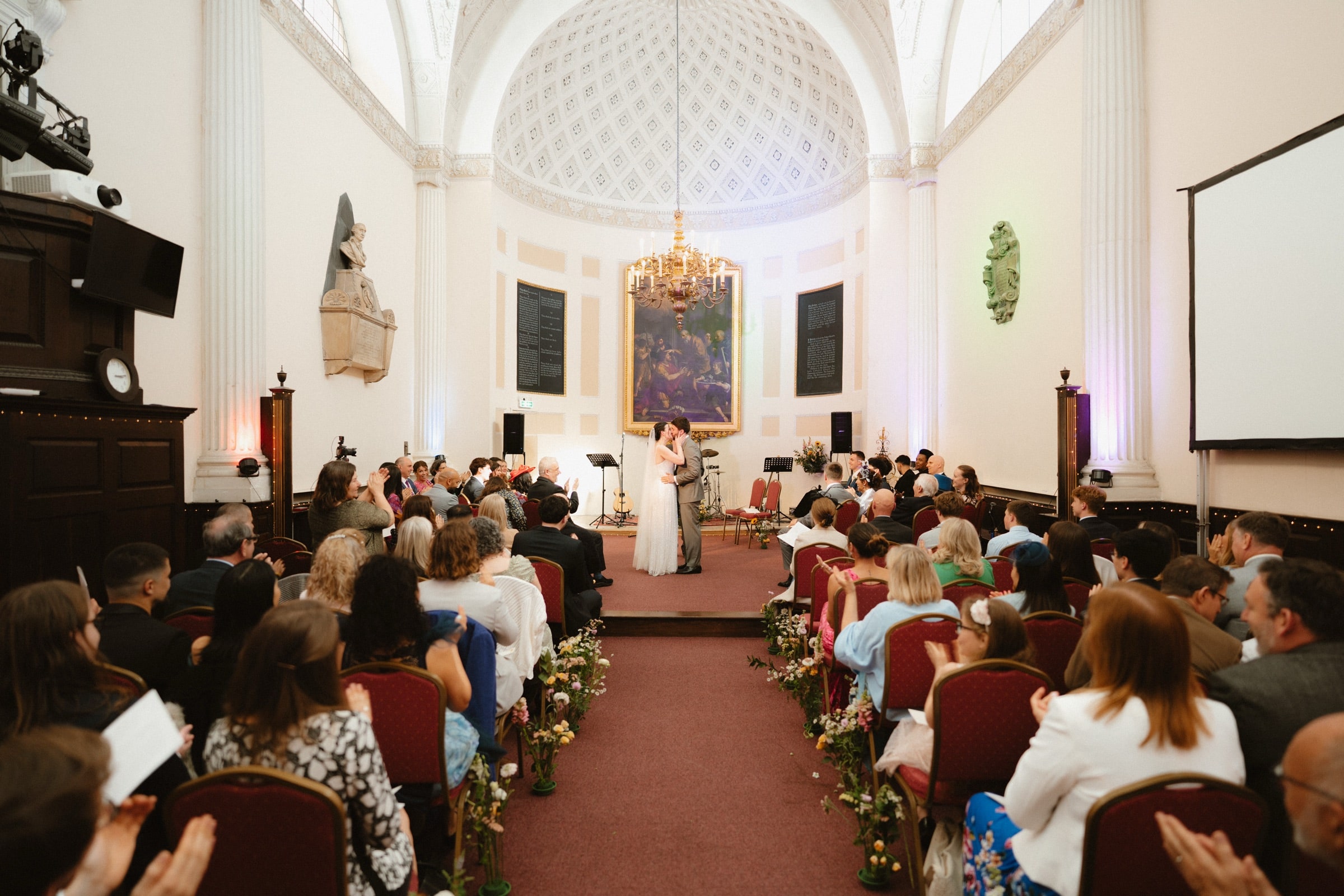 A wedding ceremony beneath the domed apse and chandelier of All Hallows-on-the-Wall, City of London