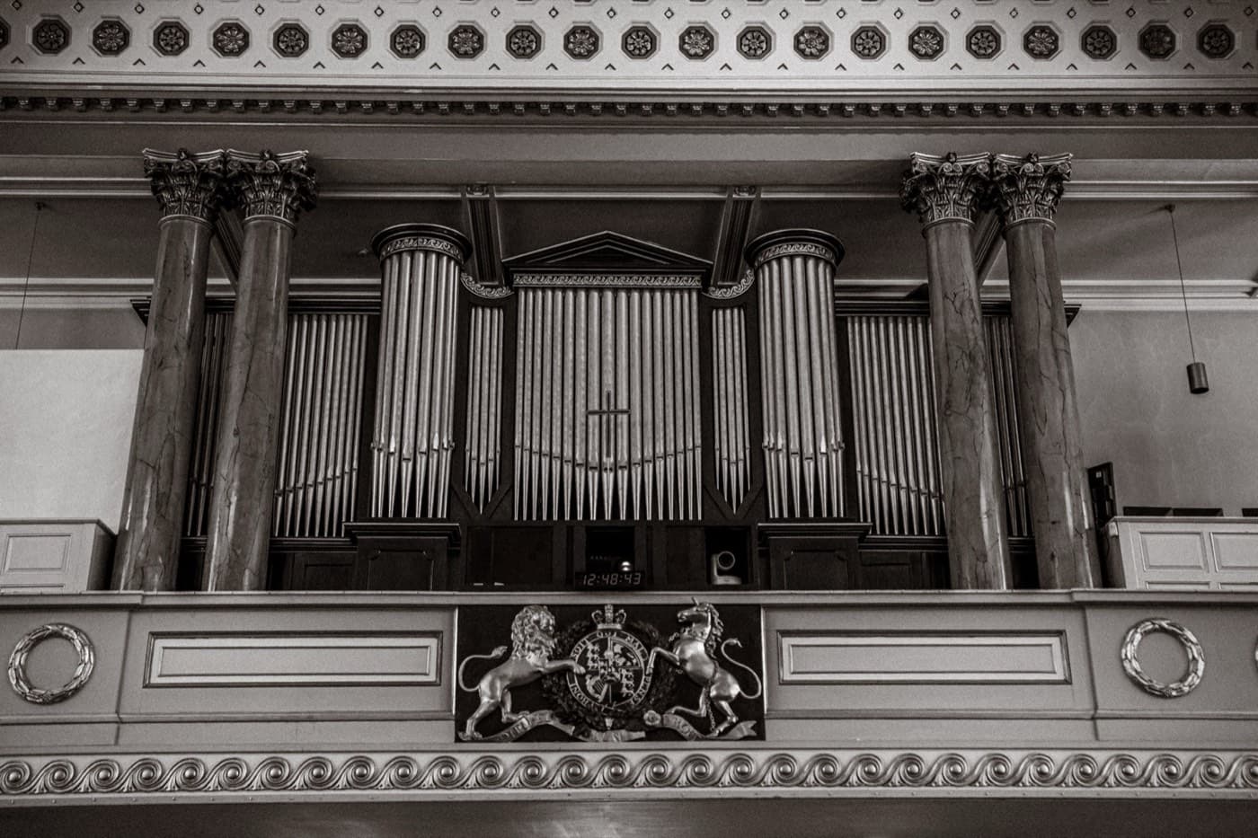 The organ gallery and royal coat of arms inside All Souls, Langham Place, in black and white