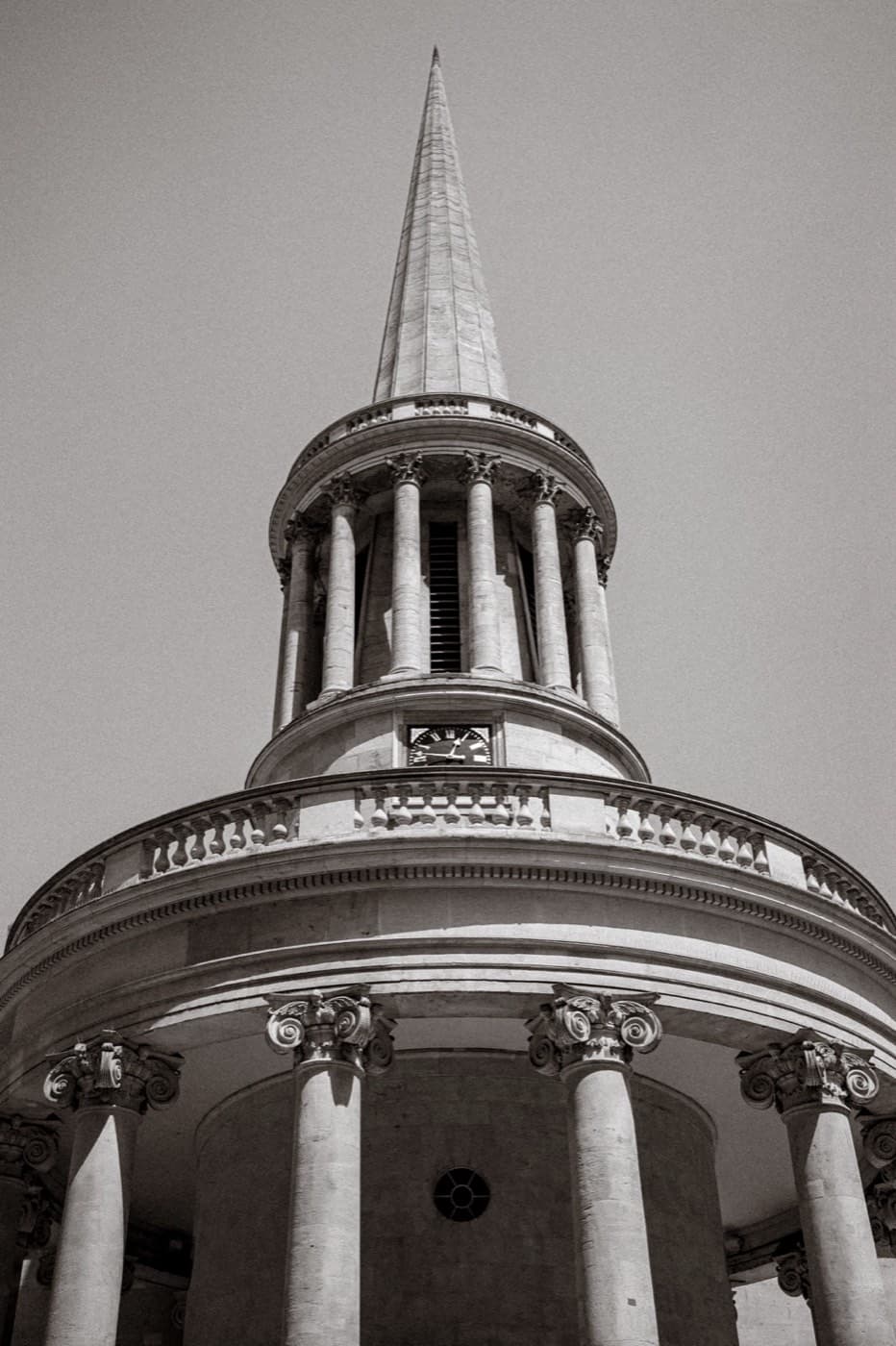 Black and white photograph looking up at the rotunda and spire of All Souls, Langham Place