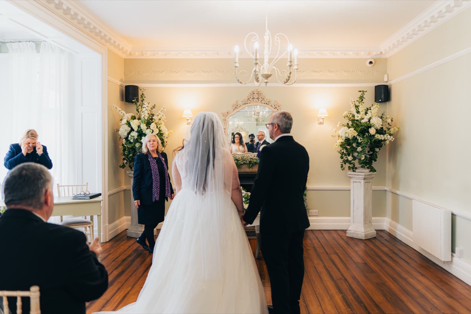 Bride entering the ceremony room at Ashton Lodge with her father