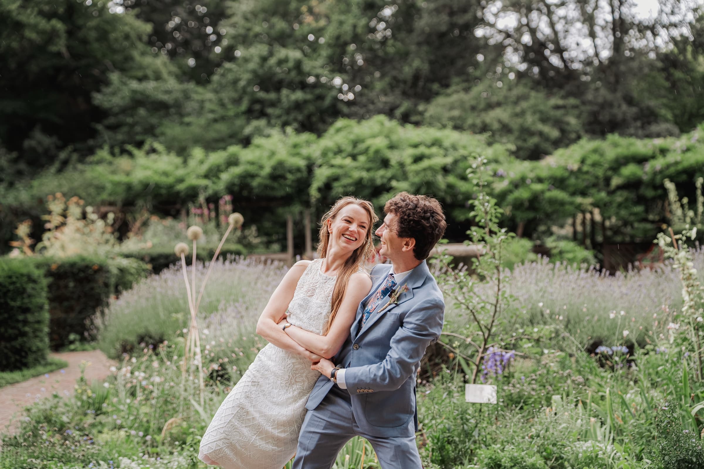 Bride and groom laughing together in the gardens at a Battersea Park wedding