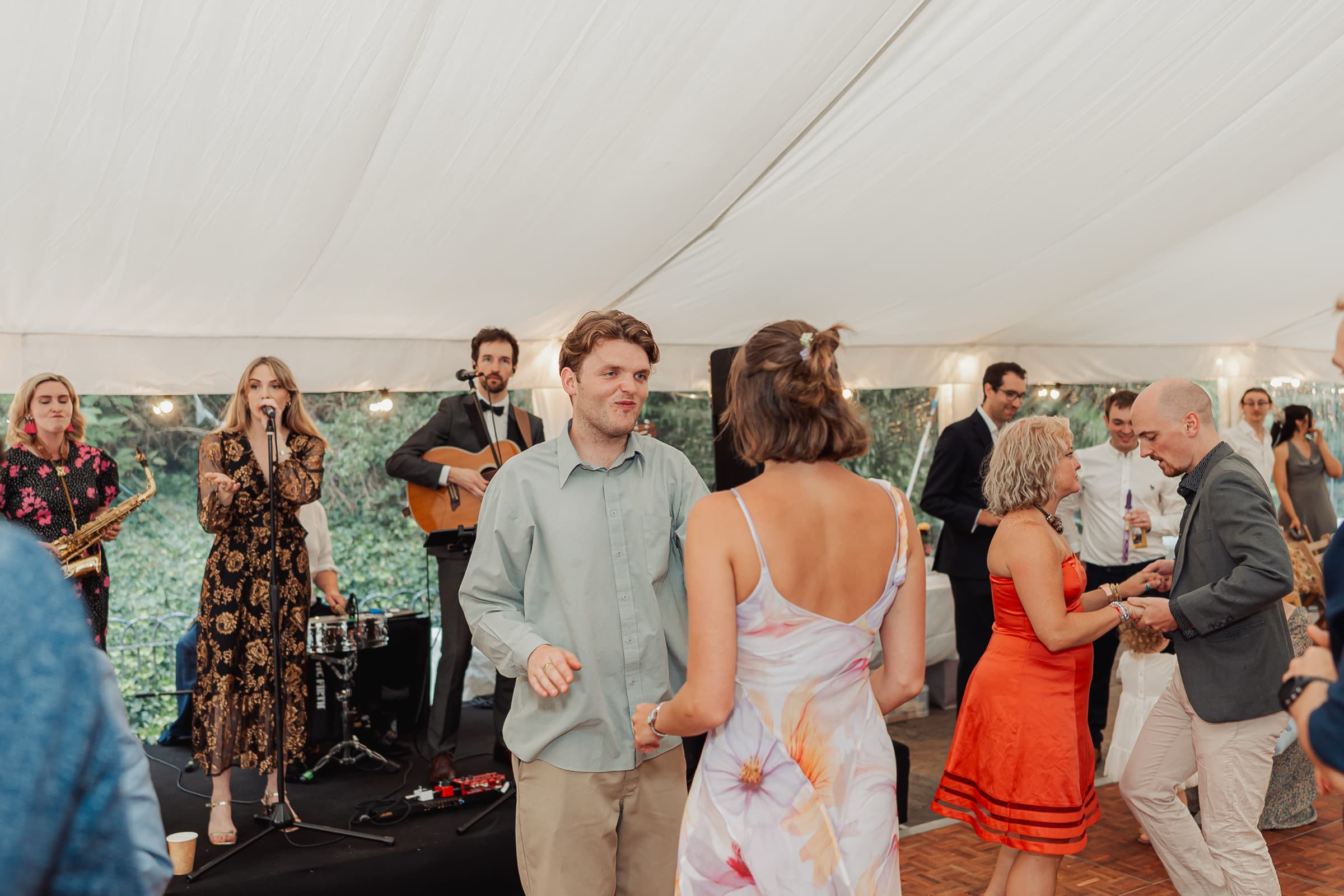 Guests dancing to a live band at a Battersea Park marquee wedding reception