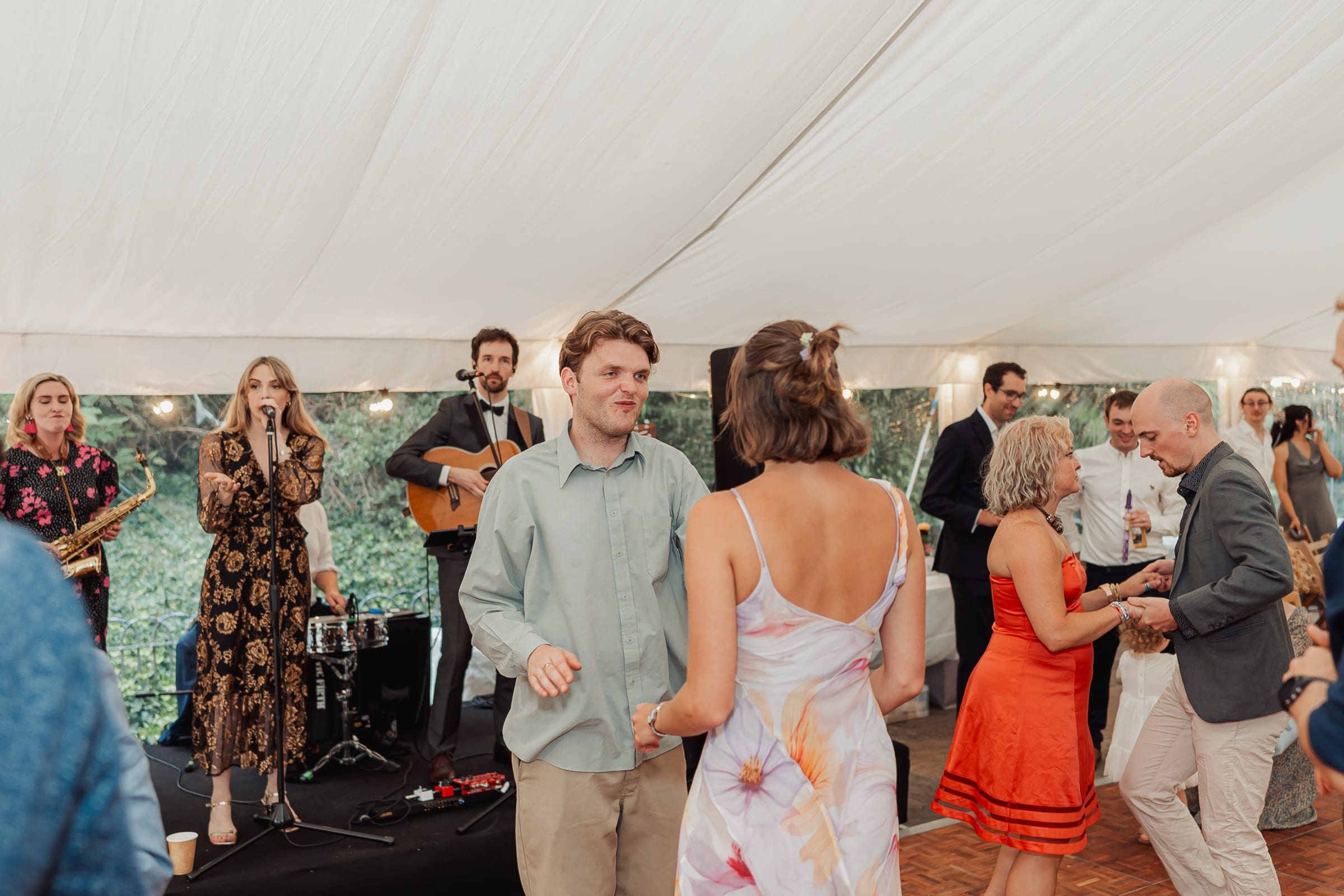 Guests dancing to a live band in a marquee