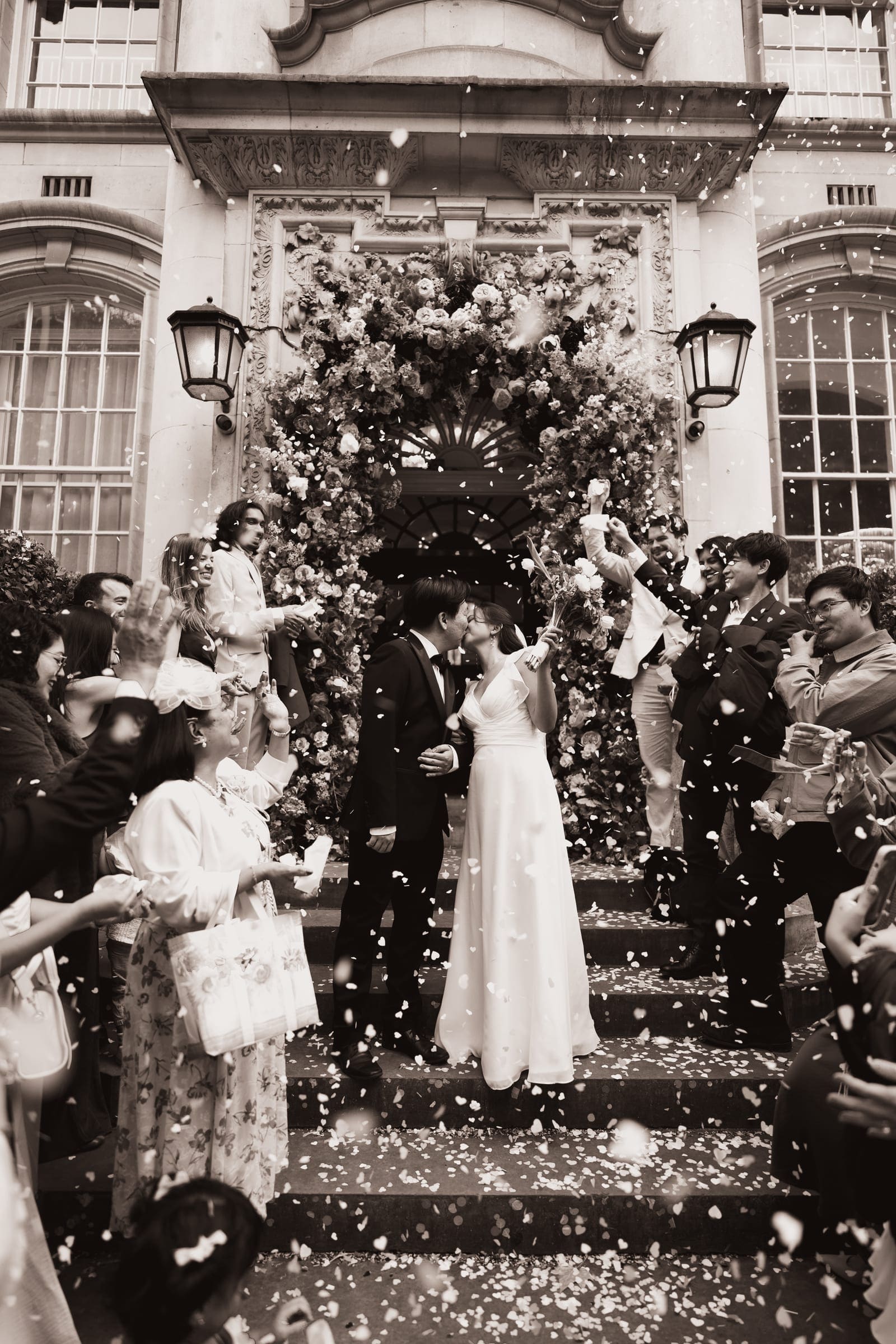 Confetti over a laughing couple on the steps of Chelsea Old Town Hall