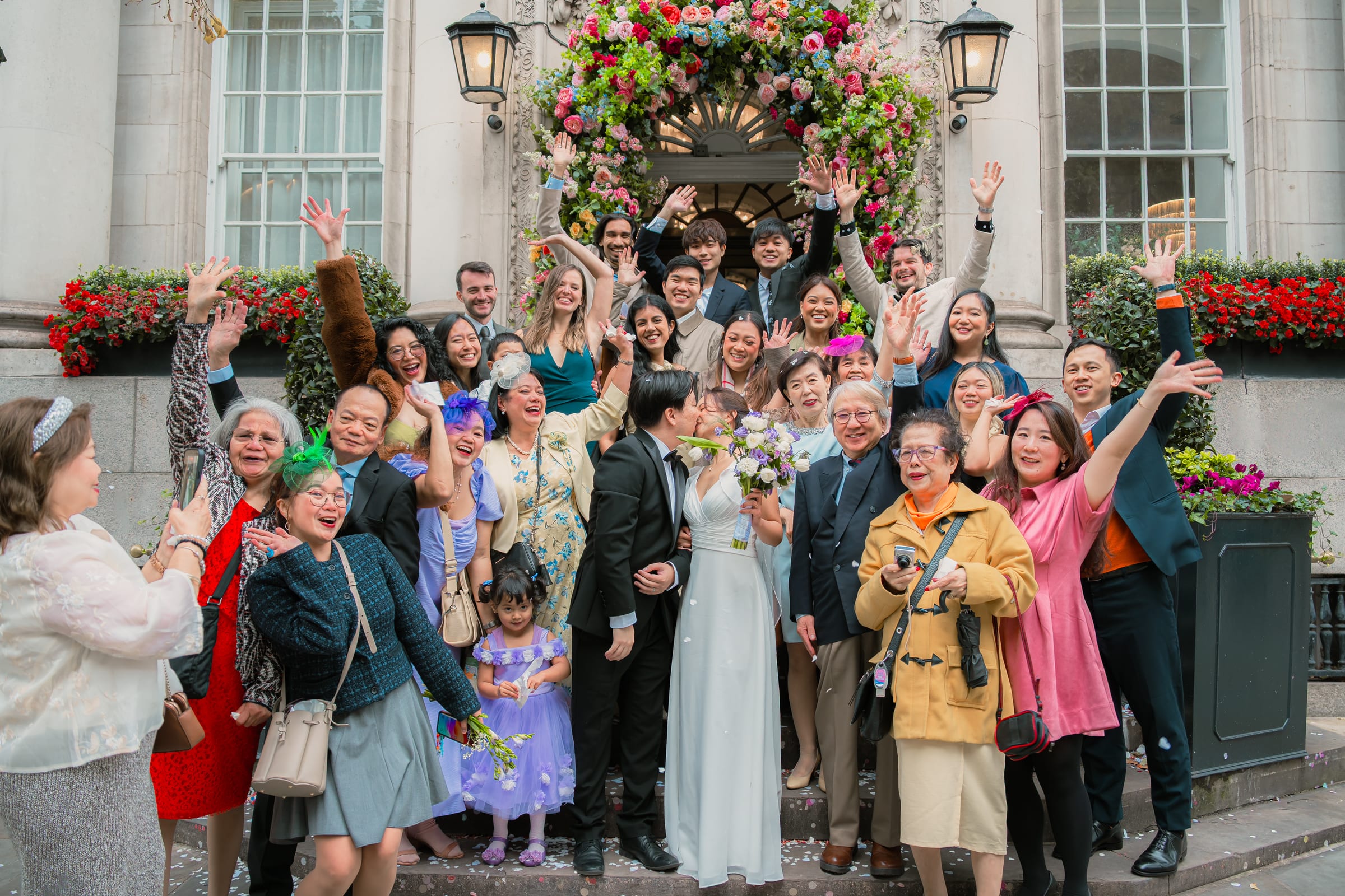 Wedding guests cheer as the couple kiss on the front steps of Chelsea Old Town Hall during the confetti throw