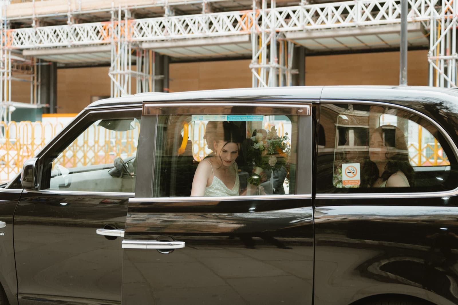 Bride arriving by classic black London cab in the City of London