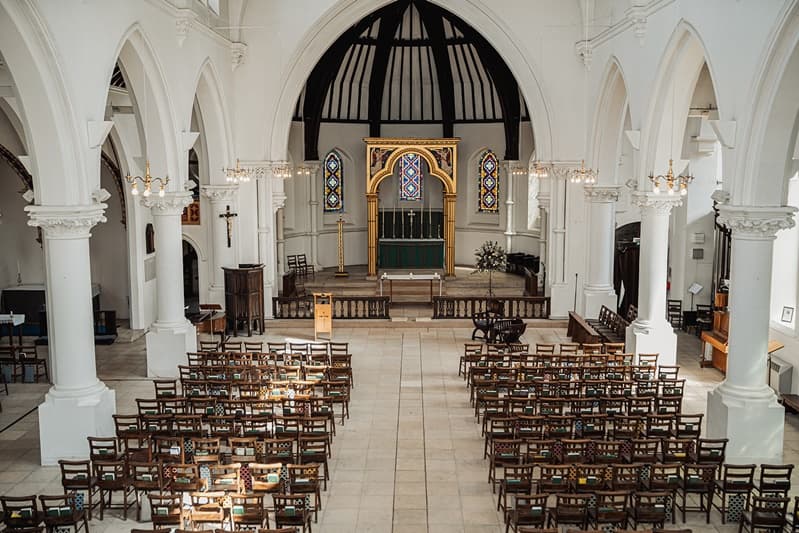 The white Gothic nave and gilded altar of St John’s Church, East Dulwich, set for a wedding ceremony