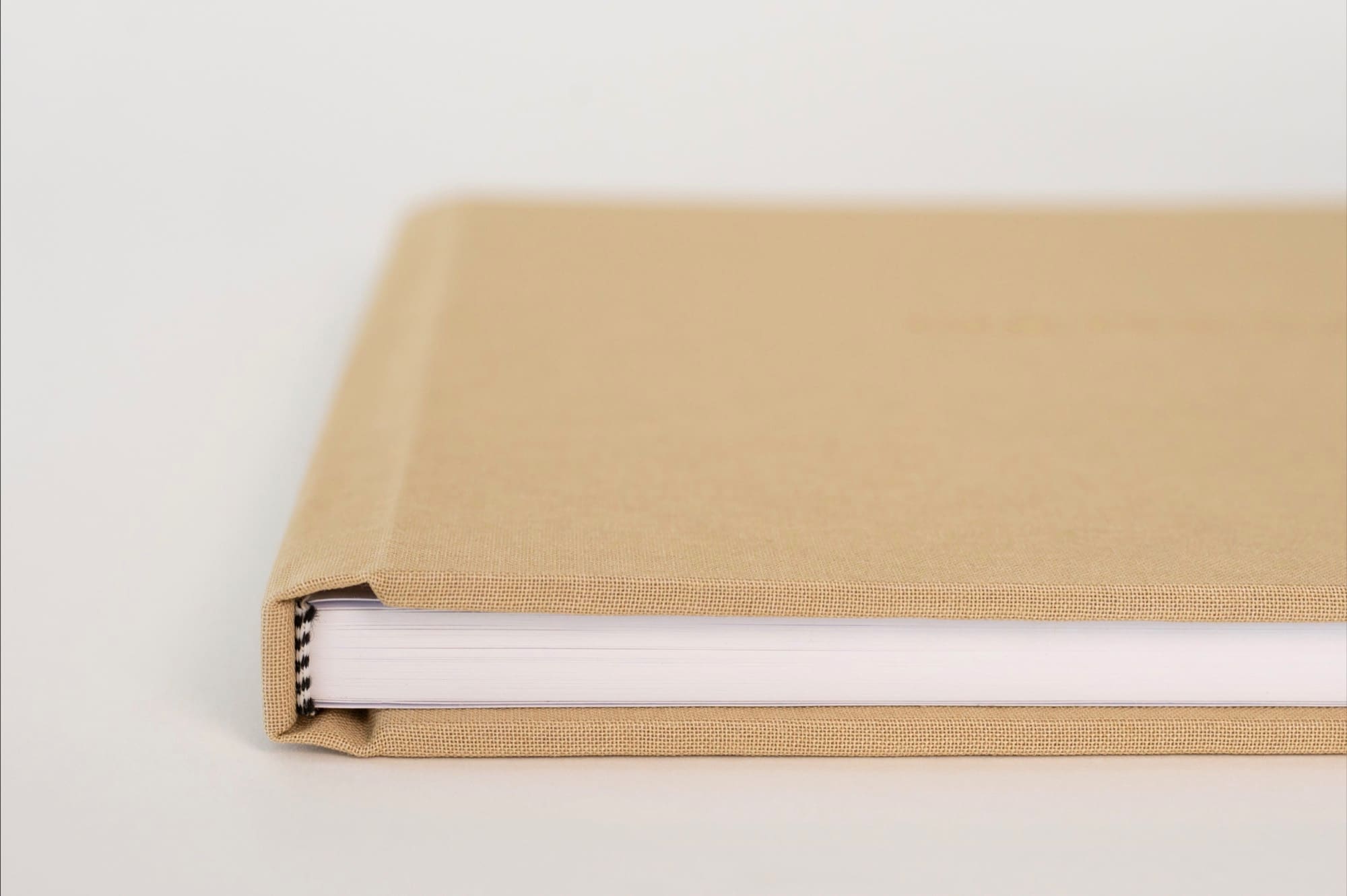 The linen-bound spine and thick pages of a wedding album