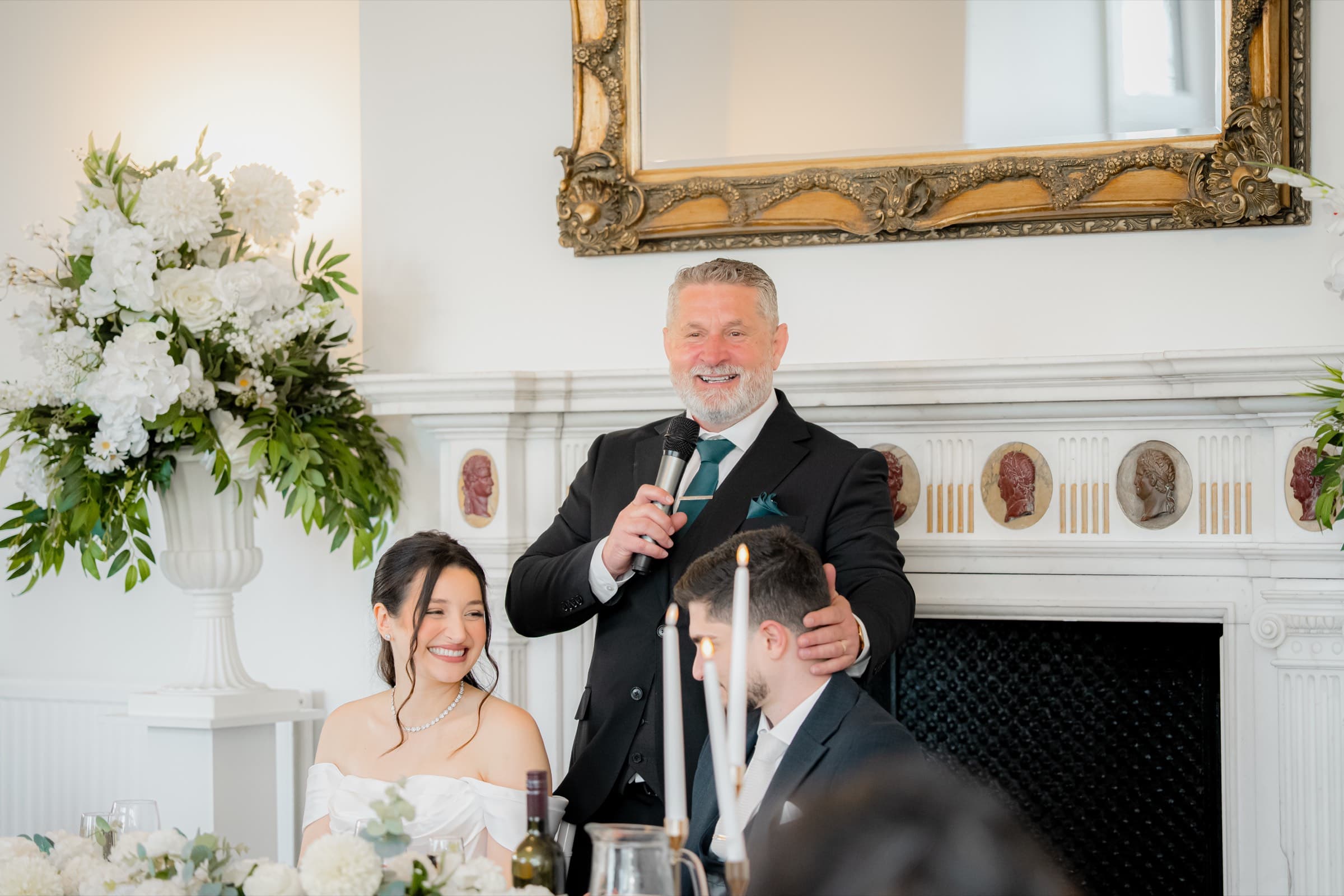 A speech being given during a wedding reception as the couple listen
