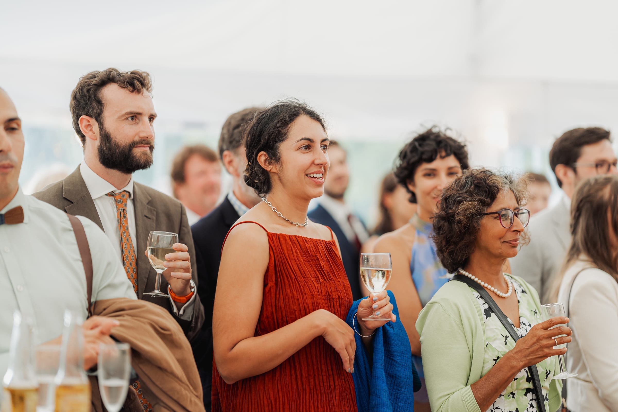 Guests smiling with drinks at a bright summer celebration