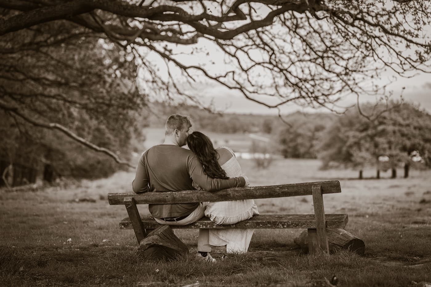 Couple on a bench looking out over countryside views, Surrey wedding photography by Evocation Photography