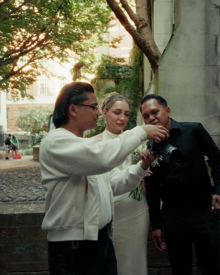 John showing a couple the back of his camera during a shoot at St Dunstan in the East